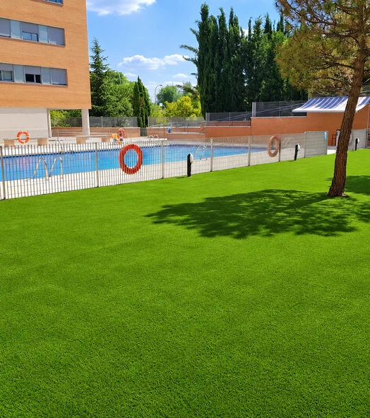Césped artificial alrededor de una piscina comunitaria