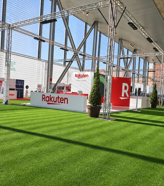 Césped artificial en un stand de feria con estructuras y expositores